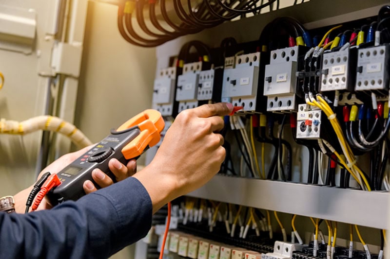Electrical System Maintenance Can Save Your Health and Home. An electrician working on wires.