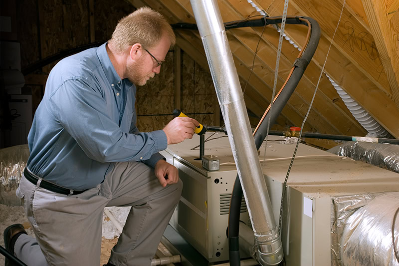 An HVAC technician repairing a furnace.